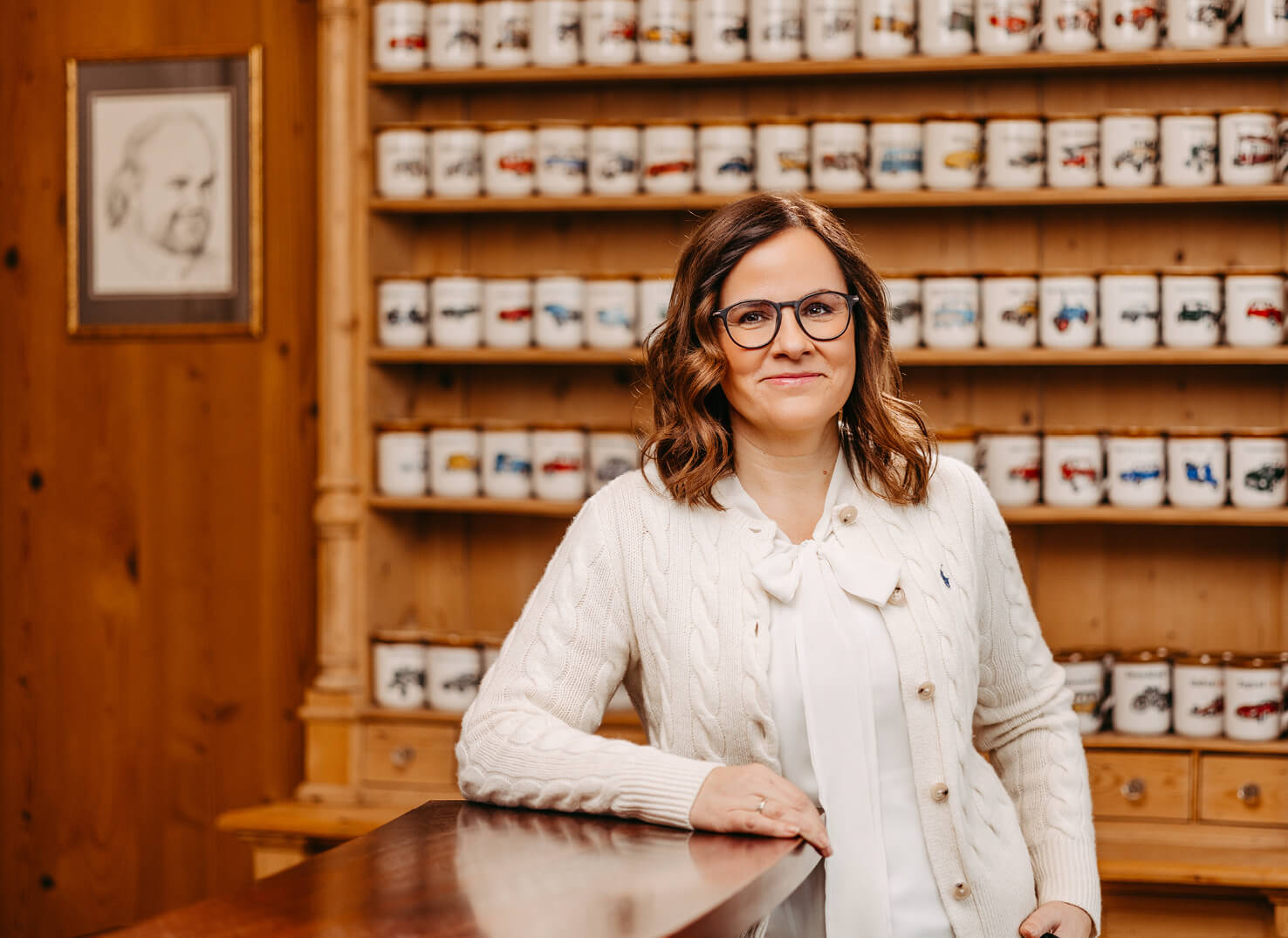 Stefanie Hofmann vor einem Regal mit den unterschiedlichsten Oldtimer-Häferln.